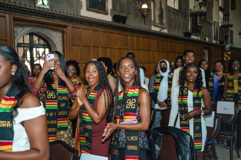 A group of students in the audience at Black Graduation smiling and laughing.