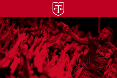 Red-tone image of TFC player pointing at the crowd.