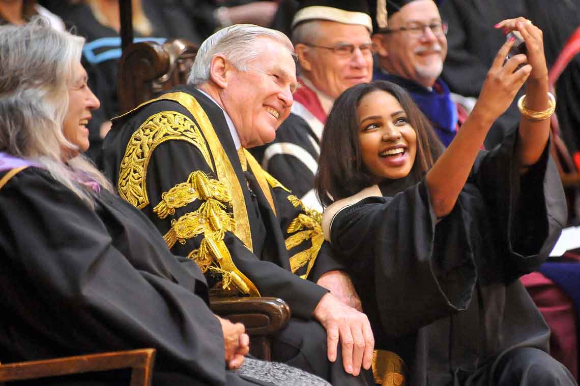 A graduating student from the Class of 2015 takes a selfie with Chancellor Michael Wilson. Photo by Ken Jones.