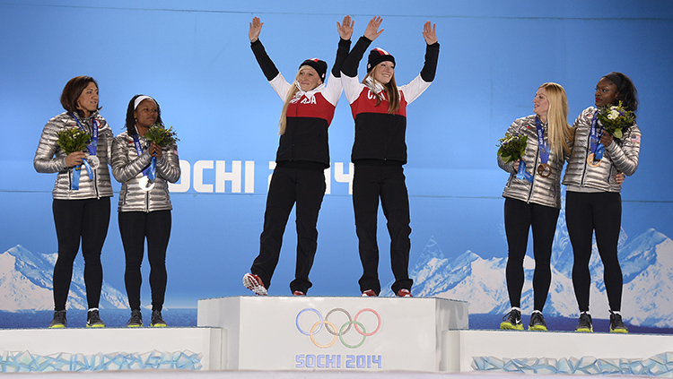 Kaillie Humphries and Heather Moyse celebrate their gold medal on the podium during the medal ceremony for the women's bobsleigh in Sochi  (photo by Pascal Le Segretain/Getty Images)