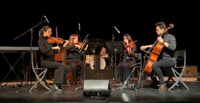 Four students perform on string instruments on stage at the Hart House Festival of Music