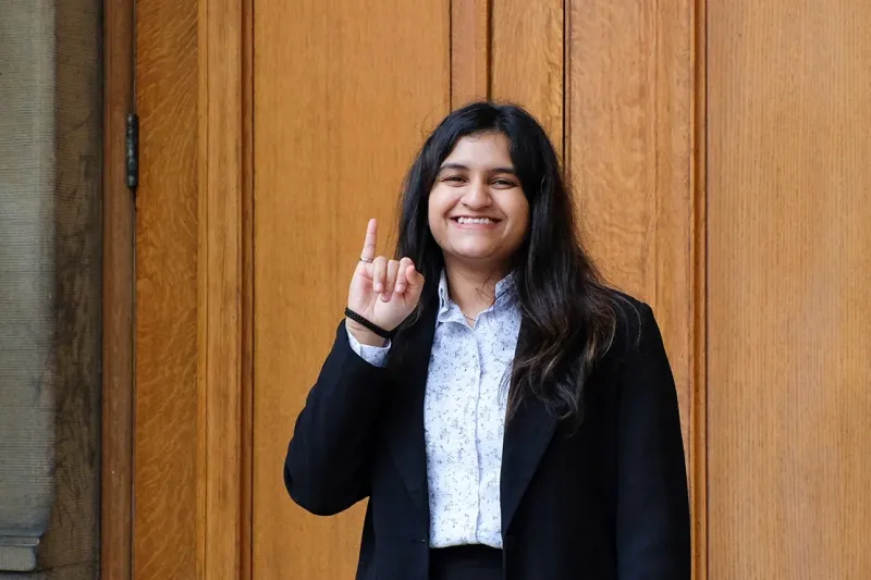 A portrait of Vishakha Pujari showing off her engineering ring on her pinkie finger