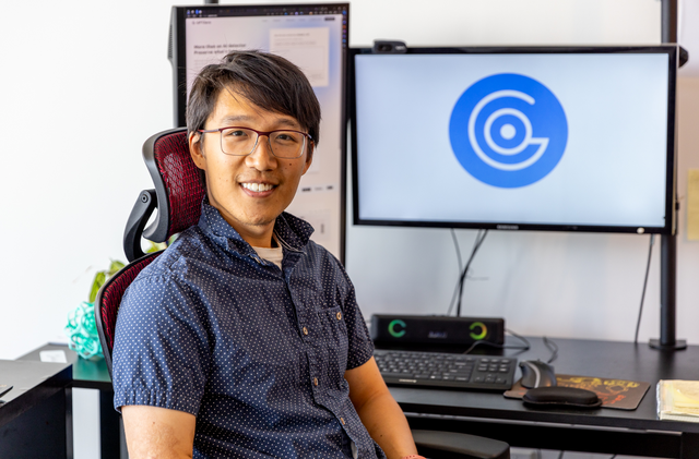 Alex Cui sitting in front of computer screens