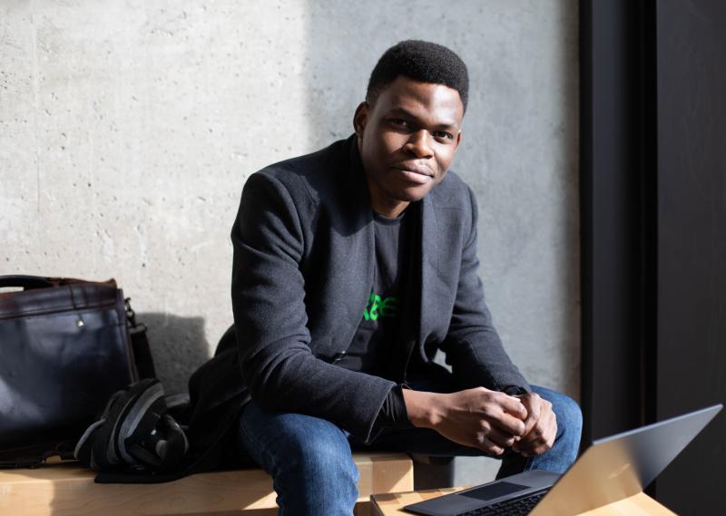 Olugbenga Olubanjo smiles as he looks up from the laptop he is working on.