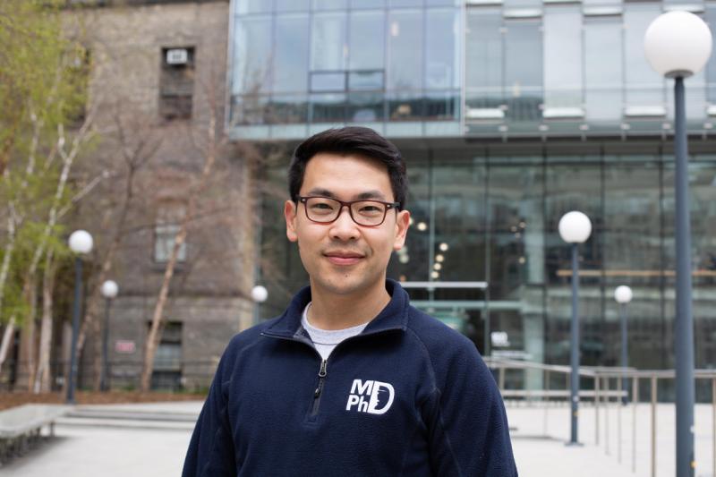 Ben Ouyang smiling and wearing his MD/PhD hoodie.