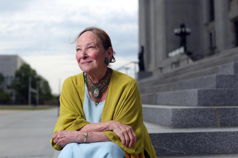 Rosalie Abella smiles, sitting on the steps of the Canadian supreme court.