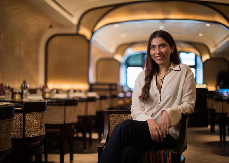 Ambica Jain sits in her restaurant Adrak Yorkville, smiling.