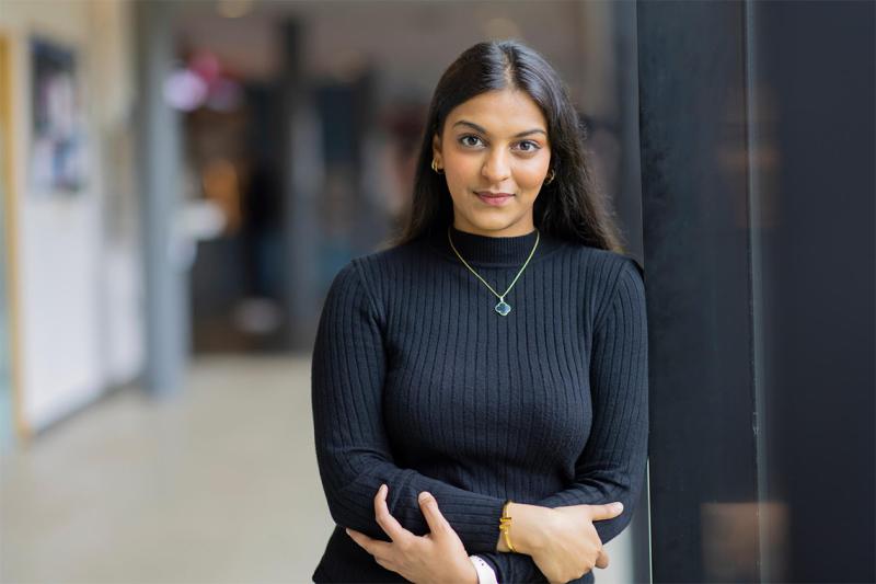 Vanshika Agarwal leans on a wall with arms crossed.