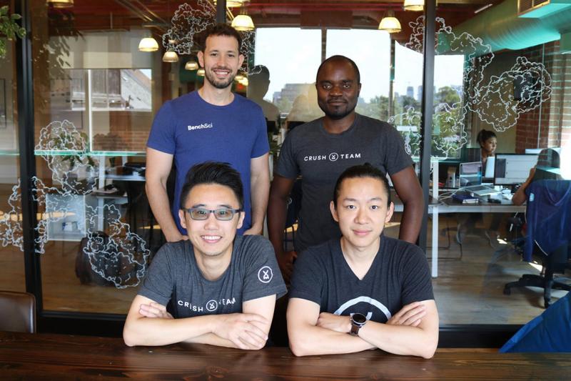 Four diverse members of the startup BenchSci pose in their modern office.