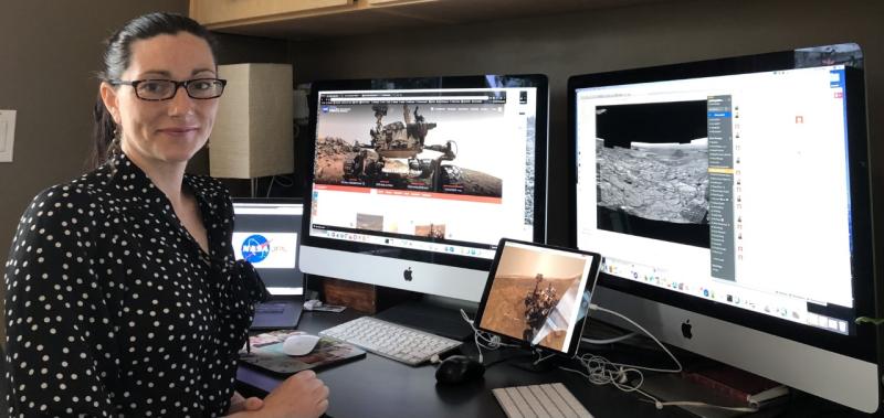 Carrie Bridge in her home office with multiple screens and keyboards surrounding her