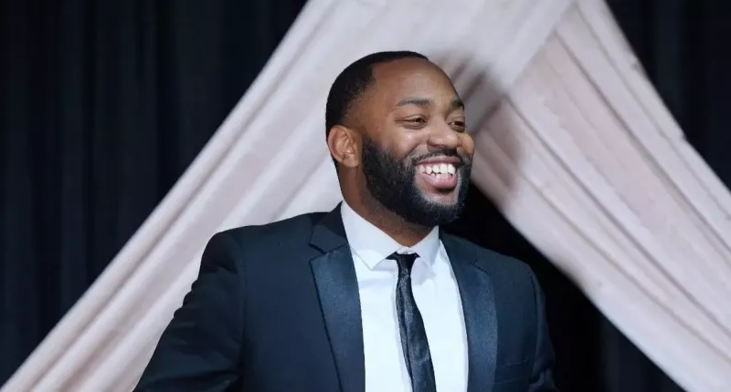 Portrait of Chris wearing a suit and smiling