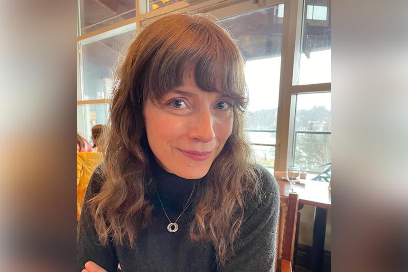Elizabeth Kalbfleisch smiles as she sits in a cafe.