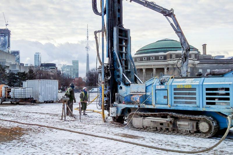A crane drills a borehole on snow-covered Front Campus for thermal performance testing.