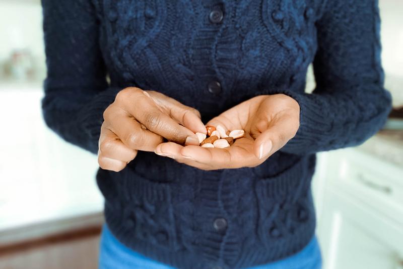 A woman picks out an almond from a handful in her palm.