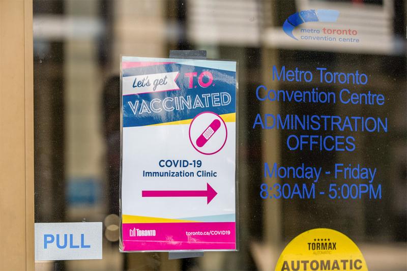 A sign for a COVID-19 vaccination clinic posted on the door of the Metro Toronto Convention Centre offices.