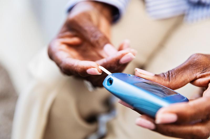 A person's hands hold a small rounded device with a tongue sticking out of it and resting on one fingertip.