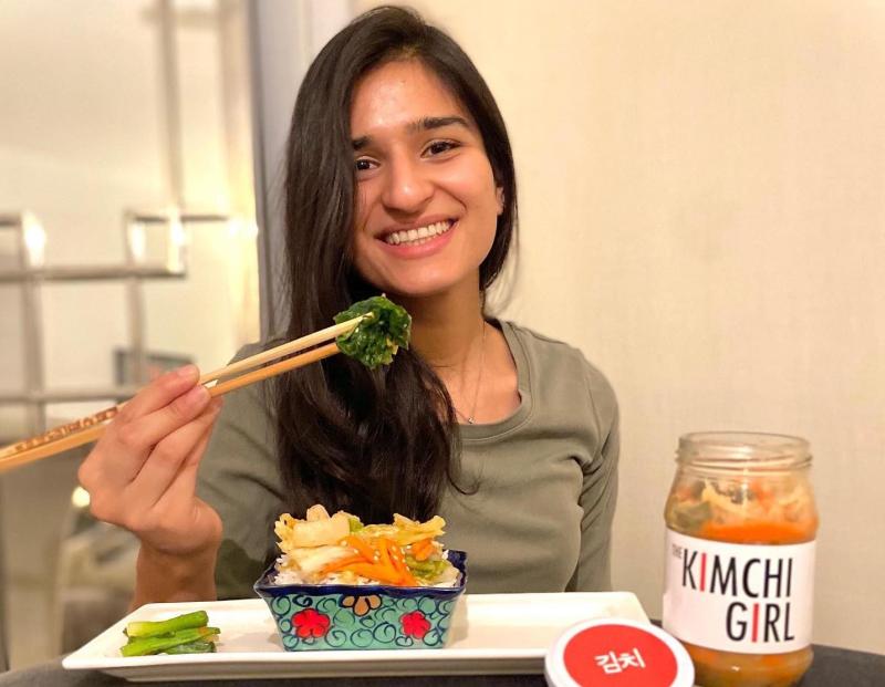 Meraj Ellahi sitting at a table and eating with chopsticks
