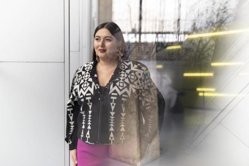 Lesley Hampton standing outside a U of T Mississauga building, smiling