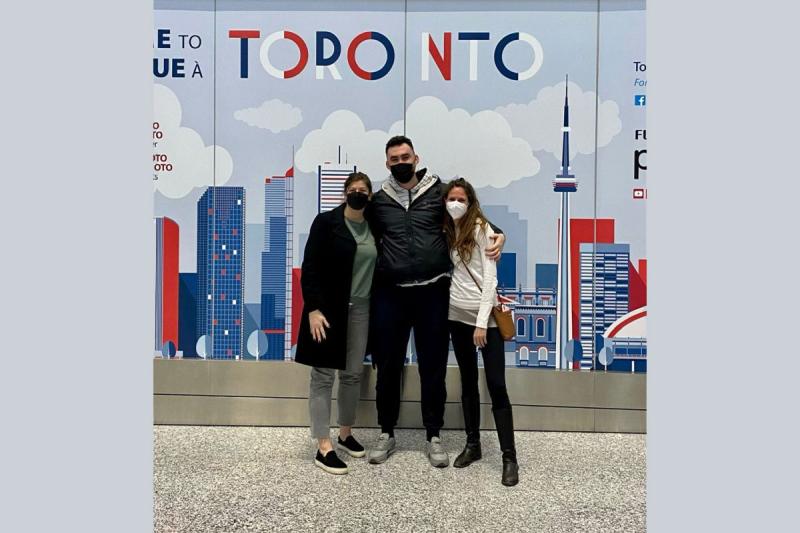Dana Wagner and friends pose for a picture in front of a mural of the Toronto skyline.
