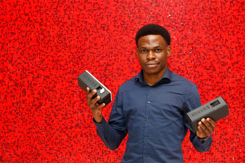 Olugbenga Olubanjo holding two solar-powered batteries