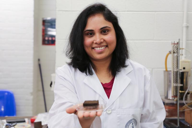 Pavani Cherukupally smiles as she holds out a small square sponge soaked in oil.