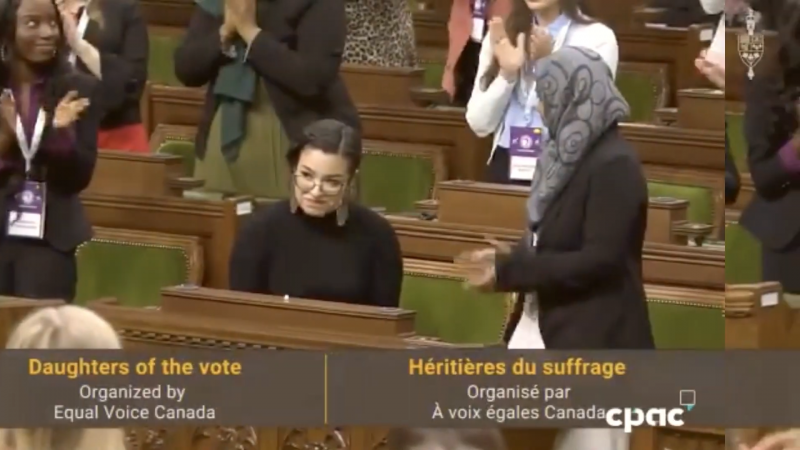 In Ottawa's House of Commons, women stand and applaud Riley Yesno. Caption reads: Daughters of the vote, Equal Voice Canada.