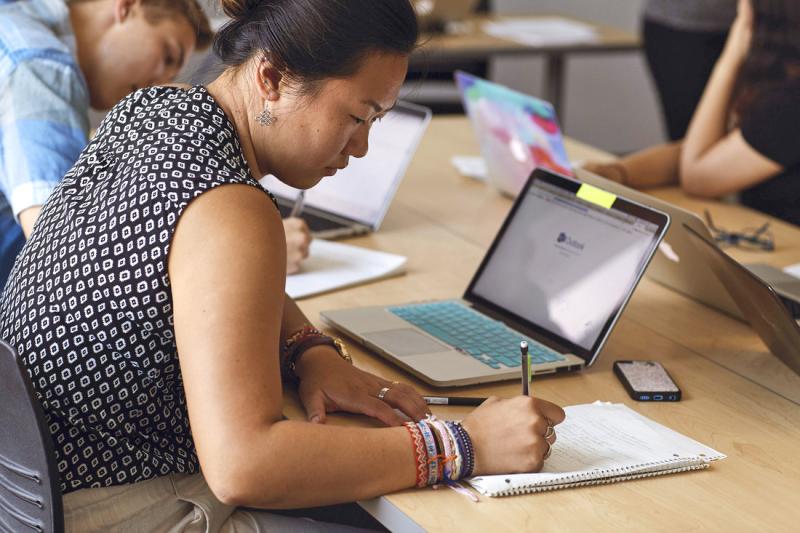 Mature student studying with notepad and laptop