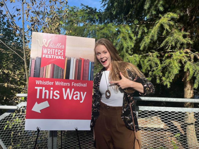 Shannon Terrell pointing to a sign at the Whistler Writer's Festival