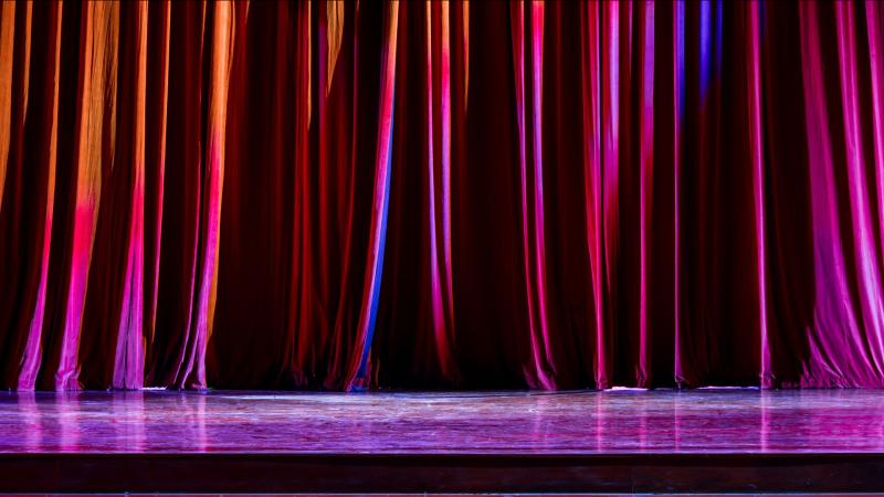 A red curtain pulled across a theatre stage