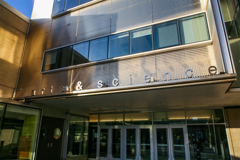 The glass doors to Sidney Smith Hall are sheltered under a sign reading: Arts & Science.