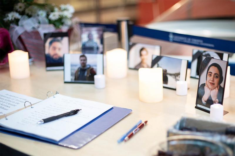 Candles stand next to photographs of the people who died in the crash of Flight 752. A book of condolences sits in front.