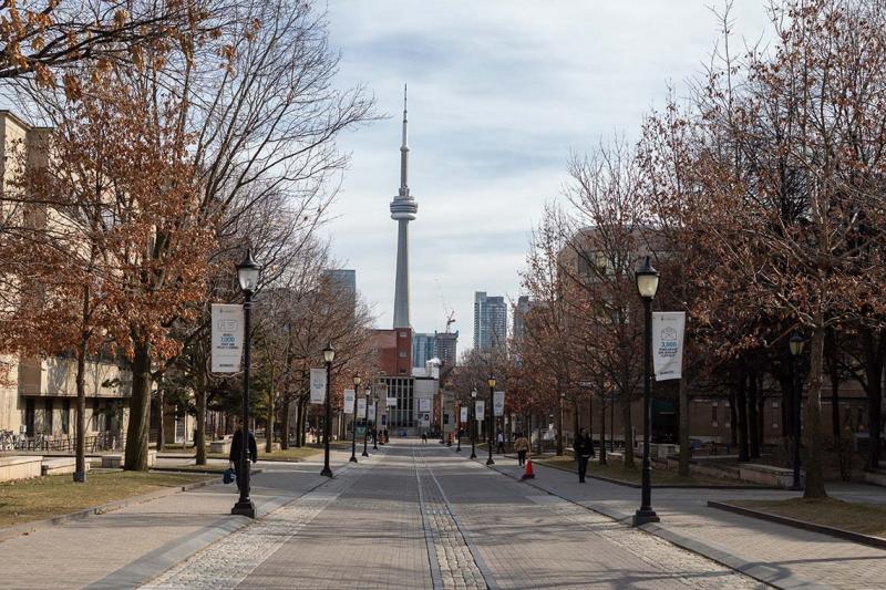 A view down a nearly-deserted St. George Street at U of T with the CN Tower visible on the skyline.