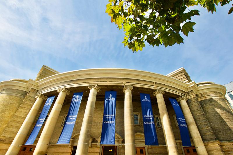 A photo looking up at Convocation Hall. The building is hung with banners that say, Congratulations to all our graduates.