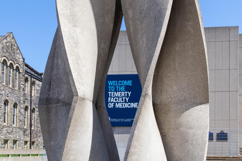 A sign reading Welcome to the Temerty Faculty of Medicine is seen framed in an abstract stone statue.
