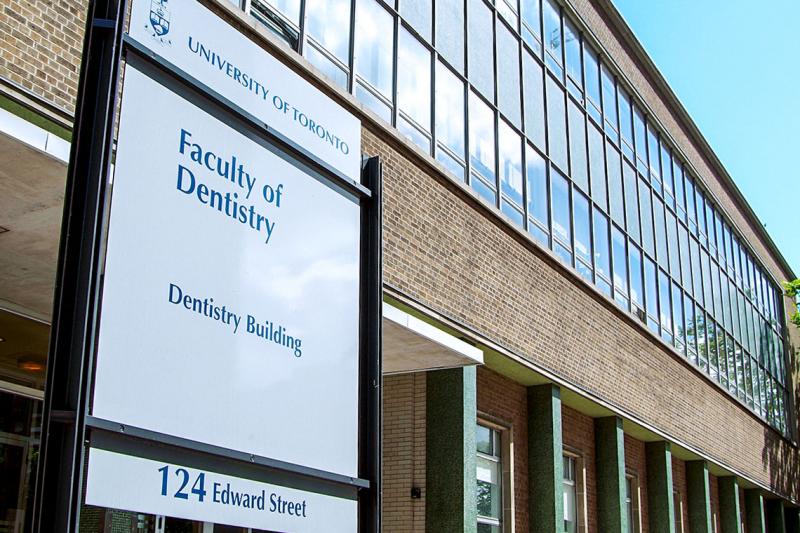 A sign saying University of Toronto Faculty of Dentistry outside a large building on Edward Street.