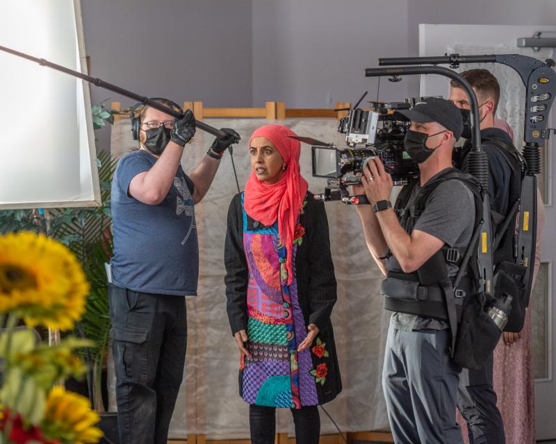 Zarqa Nawaz surrounded by a camera crew