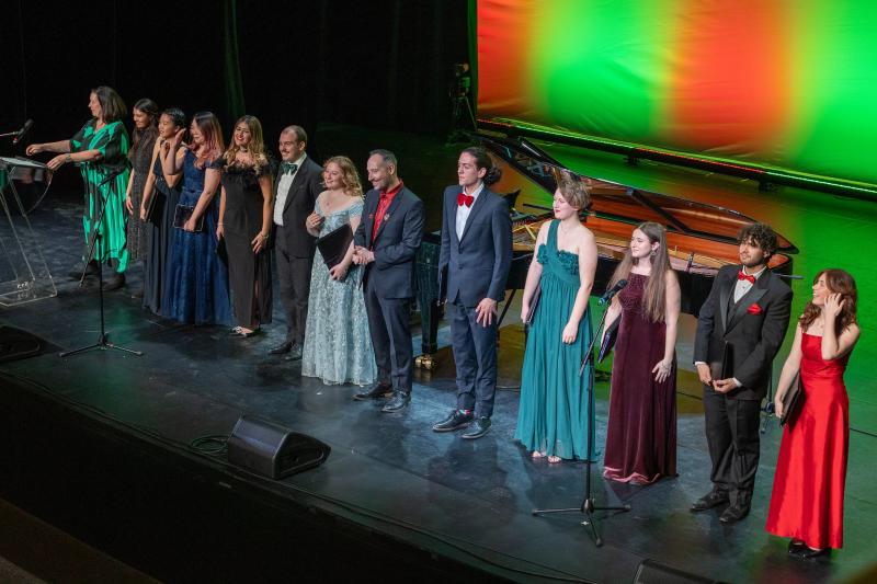 Singers standing in a row on stage at the end of the concert
