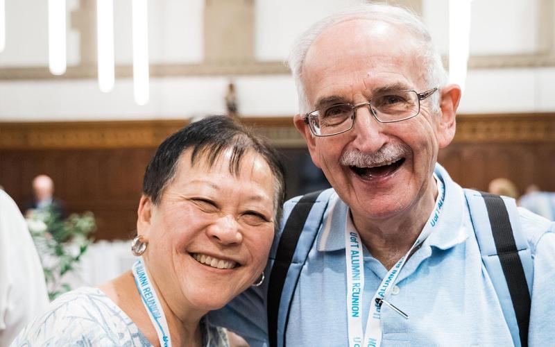 Two alumni smiling at the camera