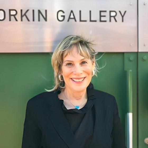 Jane Corkin standing against a door. 