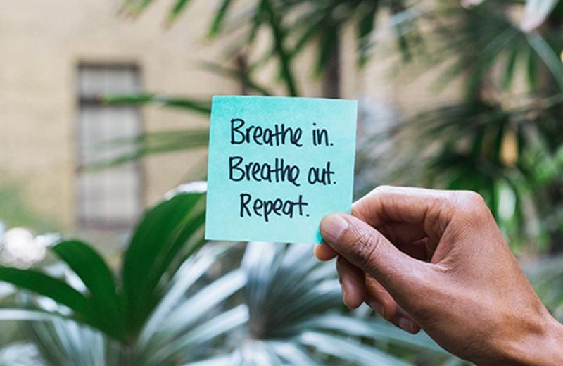 Blue Post It Note saying Breathe In, Breathe Out, Repeat