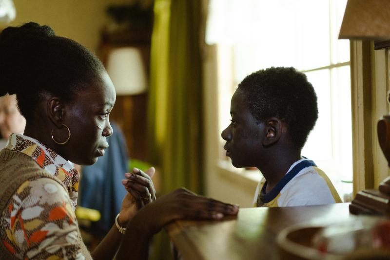 Rico (played by Rayan Dieudonné) and his mother, Erzulie (played by Penande Estime), talk next to a window.