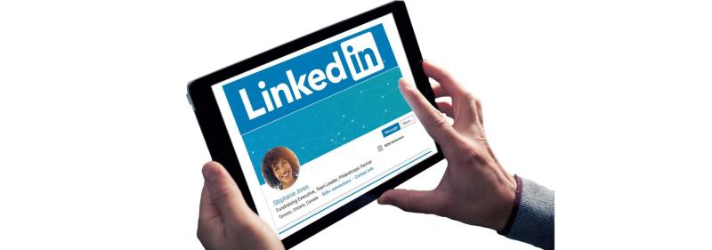 Tablet held to view LinkedIn profile webpage