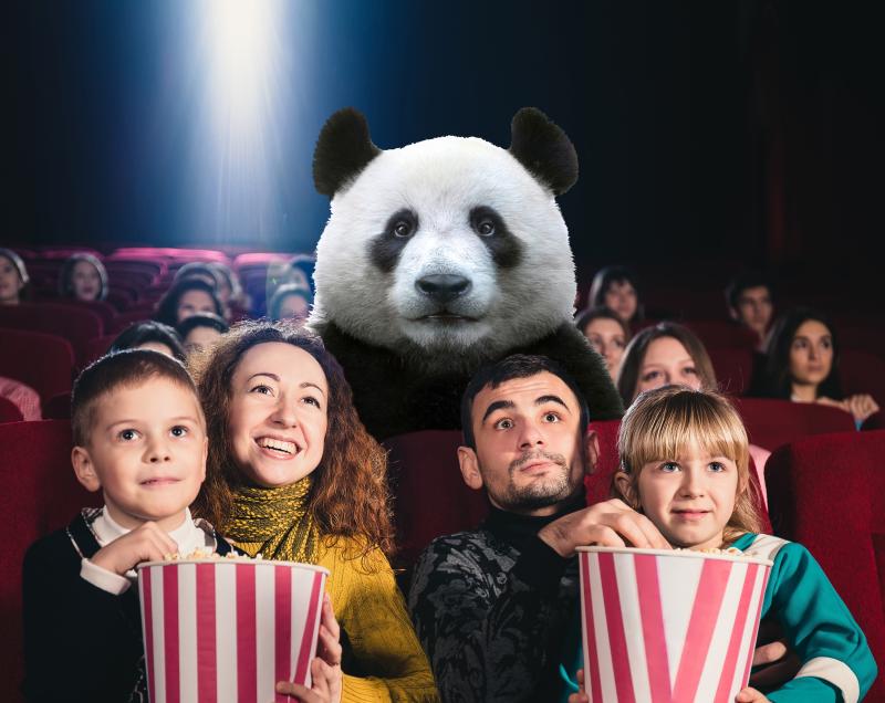 A family watching a movie with a panda in a theatre