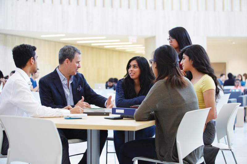 Image of people around a table having a discussion.