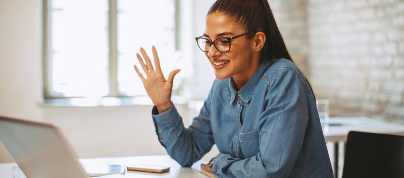 Person waving at computer screen