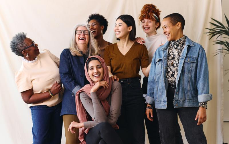 Group of women laughing as they pose for a picture together