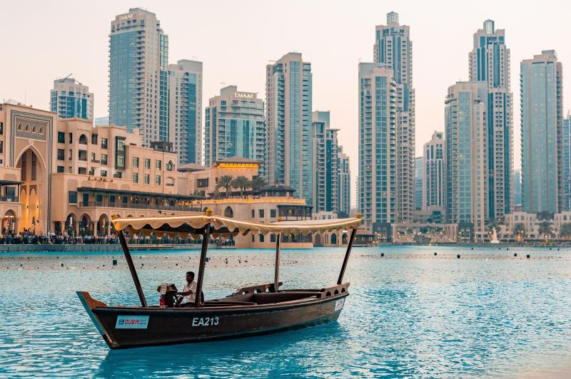Dubai scene with boat in water and buildings in the background