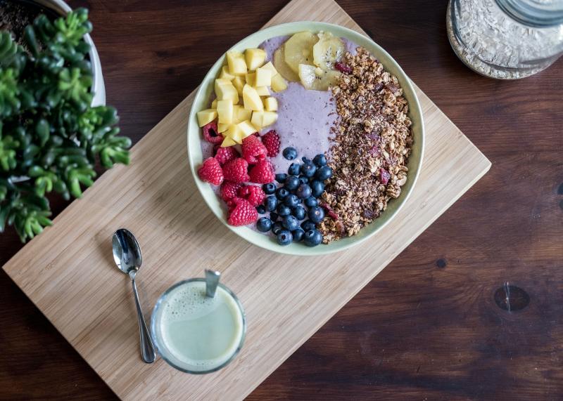 bowl of fruit on a table with a spoon