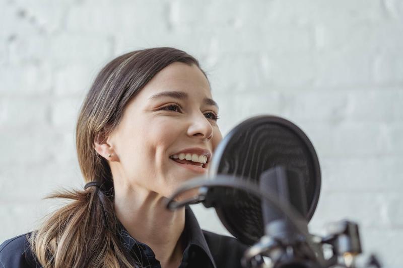 Woman speaks into microphone with smile