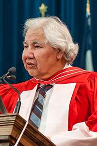 Murray Sinclair, wearing academic robes, speaks at a podium in Convocation Hall.